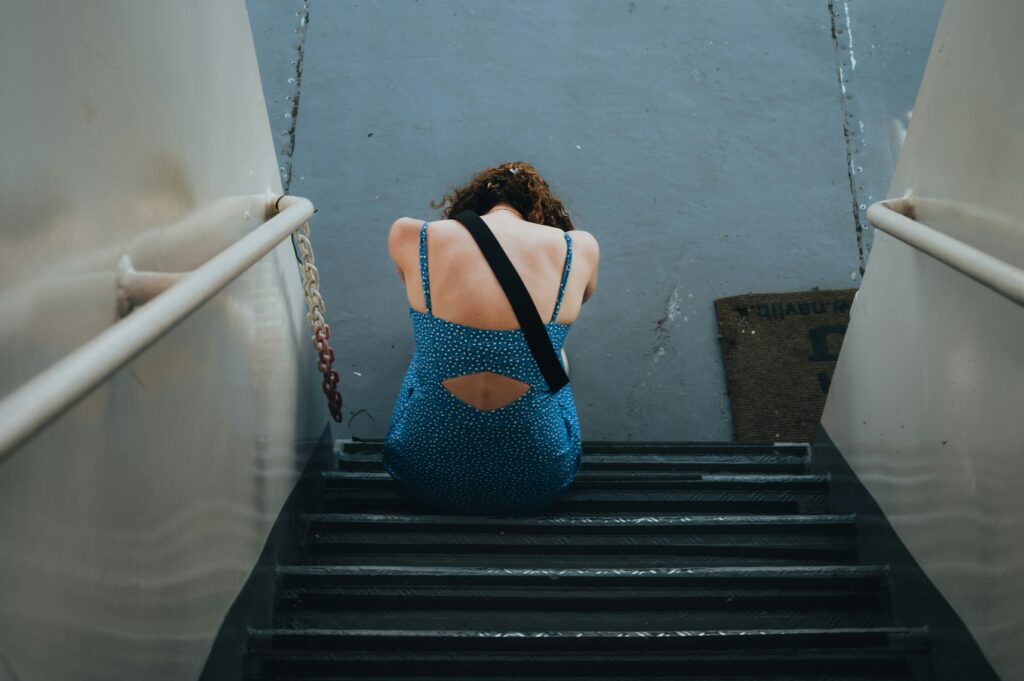 istvan szitas hybwcdyysk0 unsplash Woman sitting alone, looking down with a distant expression—reflecting emotional pain, confusion, and relationship struggles.